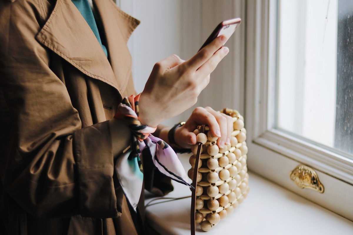 Person checking a phone beside a window